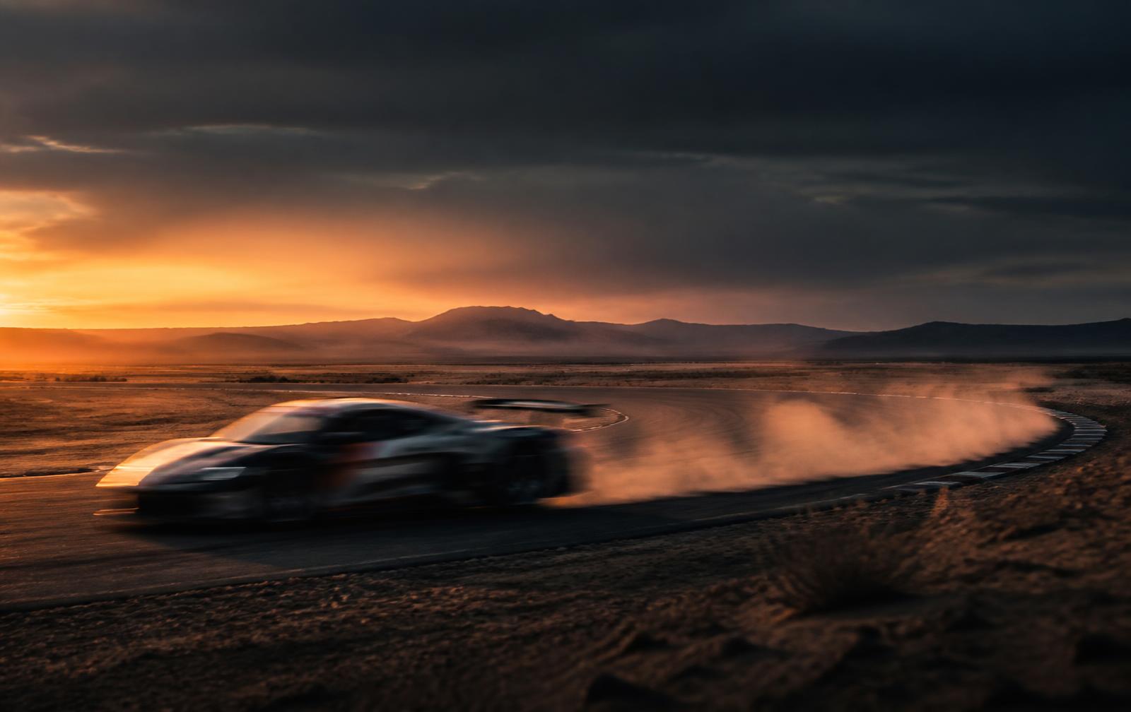 Race car at speed on a desert circuit at dusk in the American West